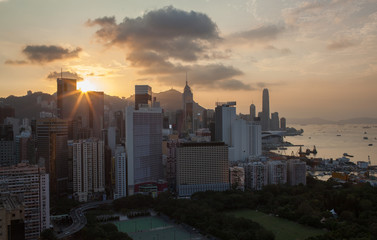 Naklejka premium Hong Kong panorama at sunset. Cityscape with high-rise buildings and water transport traffic in the harbour