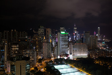 Night view of Hong Kong. Cityscape with illuminated high-rise architecture, highways and football fields