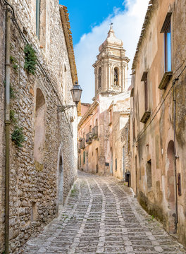The narrow street of Erice with the church tower in background, Sicily, Italy