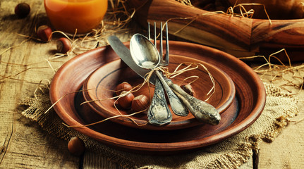 Autumn table setting with earthenware, vintage wooden background