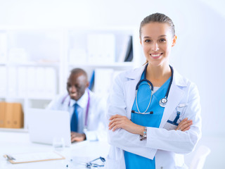 A smiling female doctor with a folder in uniform indoors