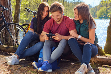 A man and two girls using a compact digital camera on the wild r