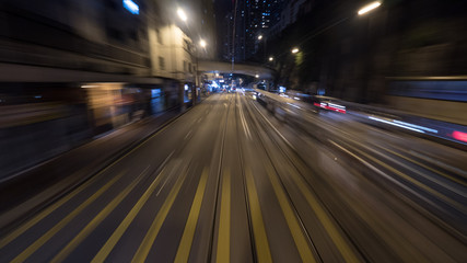Fototapeta na wymiar View to the night road from moving tram in Hong Kong. Shot in motion