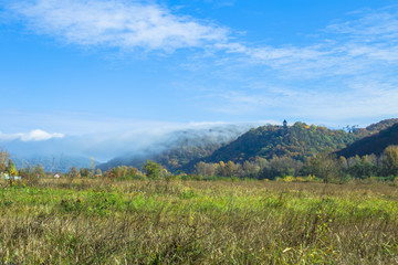 Fototapeta premium Kam'yanitsya, Ukraine, October 23, 2016: Nevytsky Castle on a background of mountains