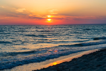 Beautiful sunset over the Black Sea in the summer.The bird flying over water. Sea landscape. Nature composition