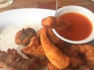Horizontal photo of closeup fried fish with chili sauce.