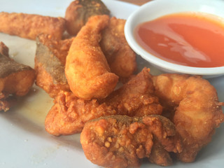 Horizontal photo of closeup fried fish with chili sauce. Shallow depth of field