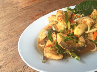 horizontal photo of fried spicy Mekong giant catfish with herb on wooden background