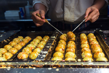 japanese chif cooking takoyaki, tagoyaki is the most popular del