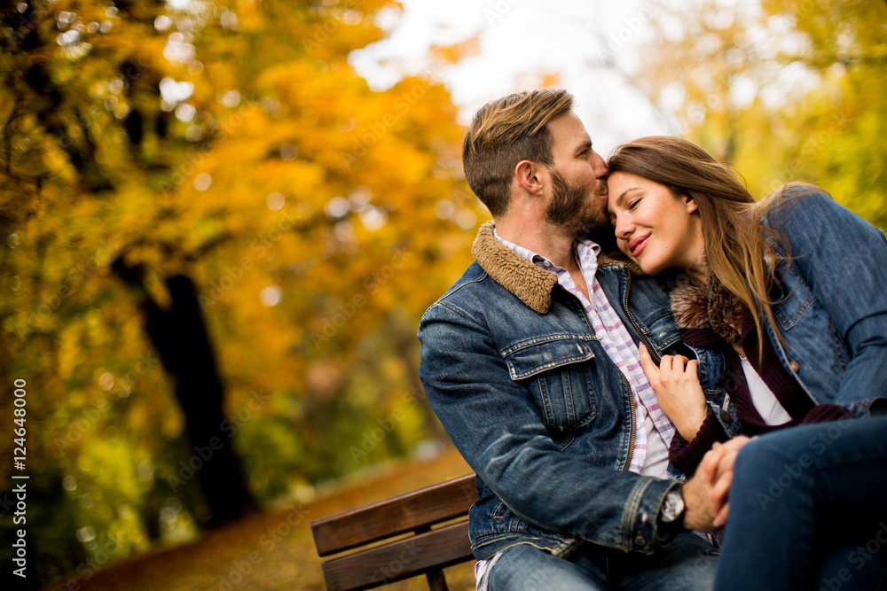 Wall mural Young couple in the autumn park