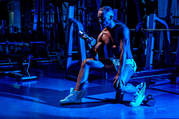 Fototapeta na wymiar Male model lifting dumbel in the gym