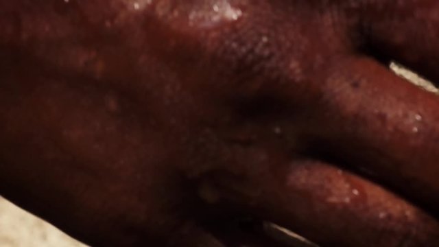 Close up of african people washing hands in water from a tap