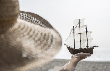 Woman hold boat model on the beach