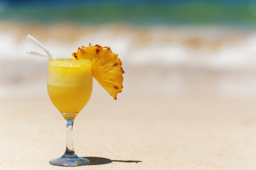 friut pineapple cocktail on sandy ocean beach