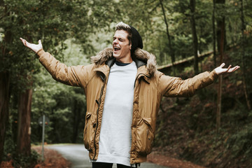 boy shouting in the forest with open arms