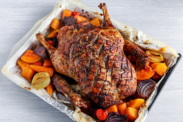 Duck roast with baked vegetables, on white wooden table, background