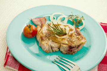 Juicy grilled pork chop with onion rings