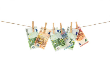 Euro banknotes hanging on clothesline on white background.