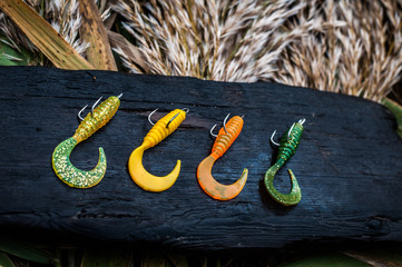 Fishing softbaits on wooden board.