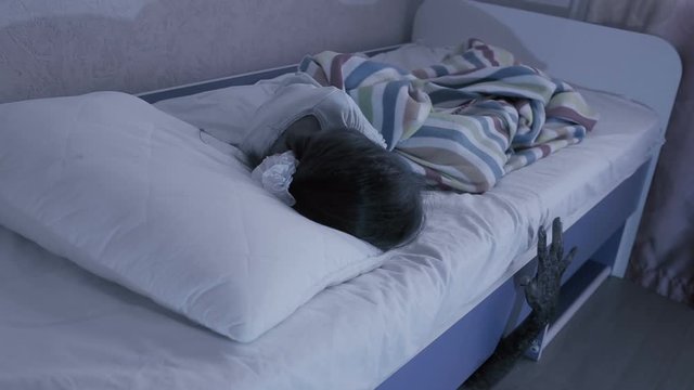 monster coming out from under little girls bed. nightmare child. halloween