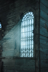 Latticed window of an old abandoned wooden church