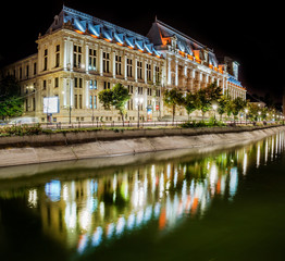 Fototapeta na wymiar The Palace of Justice at night, near Dambovita river. Photo taken at dusk. Palatul Justitiei - Bucharest, Romania.