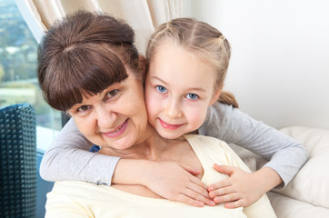 Senior lady with granddaughter happy together in domestic environment