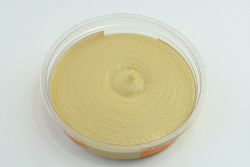 Hummus Dip in plastic container against white background