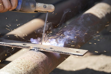 Iron welding with bright light and smoke at manufacturing
