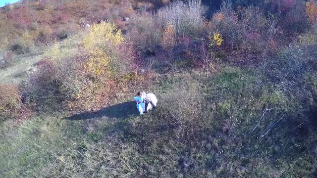 Newlyweds dance in the field aerial view