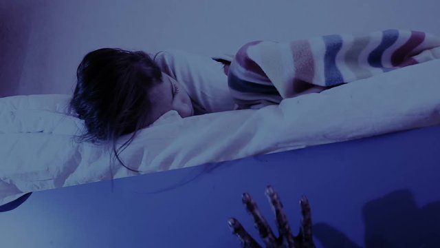 monster coming out from under little girls bed. nightmare child. halloween