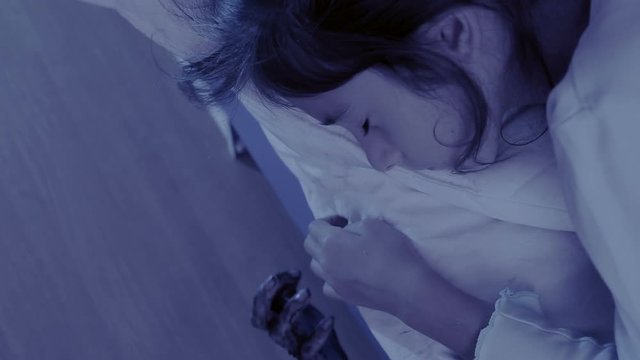 monster coming out from under little girls bed. nightmare child. halloween