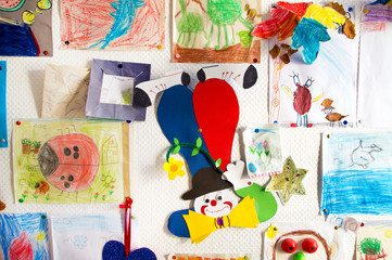 Handgemalte Kinderbilder an der Wand im Kindergarten