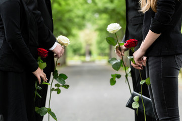 Familie erweist Verstorbenen letzte Ehre und steht im Spalier auf Friedhof bei Beerdigung