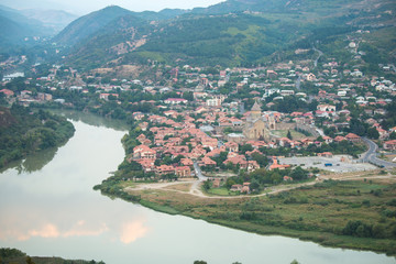 Old georgian town Mtskheta in the mountains with blue sky and green hills