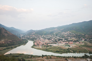 Old georgian town Mtskheta in the mountains with blue sky and green hills