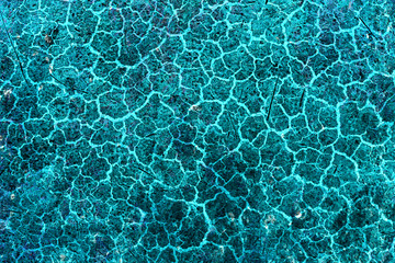 Cracked and peeling paint on the blue wall. Close-up view. Grunge old texture. Abstract background. Vintage style. Scratched and chipped surface.