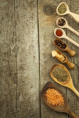 Spice in Wooden spoon. Herbs. Cinnamon and other on a wooden rustic background. Pepper. Large collection of different spices and herbs. Salt, paprika. Sale of spices.
