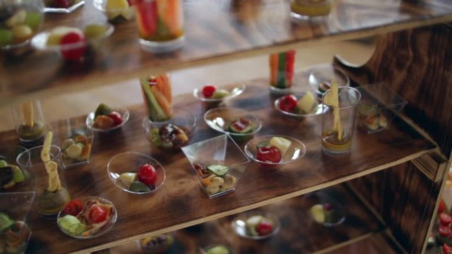 Various snacks on a buffet table at the event, the camera moves smoothly