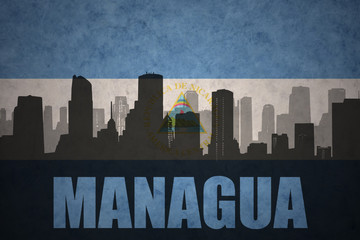 Fototapeta premium abstract silhouette of the city with text Managua at the vintage nicaraguan flag
