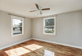 Sunny unfurnished room with hardwood floor in old empty house