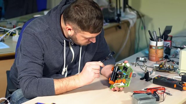 Man repairing broken device in workshop