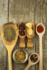 Spice in Wooden spoon. Herbs. Cinnamon and other on a wooden rustic background. Pepper. Large collection of different spices and herbs. Salt, paprika. Sale of spices.
