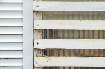 White wall with wooden blinds with horizontal bars