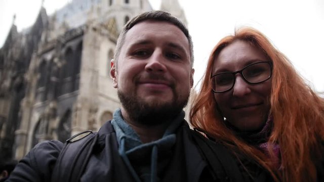Young couple european beard man and red hair female makes a selfie near Stephansplatz in Vienna, Austria, rainy autumn