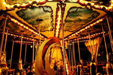 vintage attraction for children at an amusement park at night with lights shining