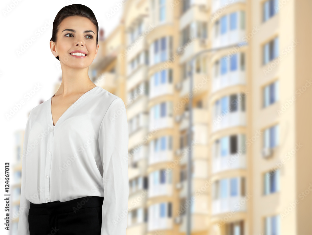 Wall mural Businesswoman on blurred building background