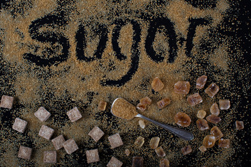 Brown sugar on black background crystal and cubes