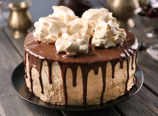 Delicious cake with meringues on table