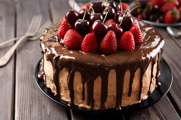 Delicious cake with cherry and strawberry on table